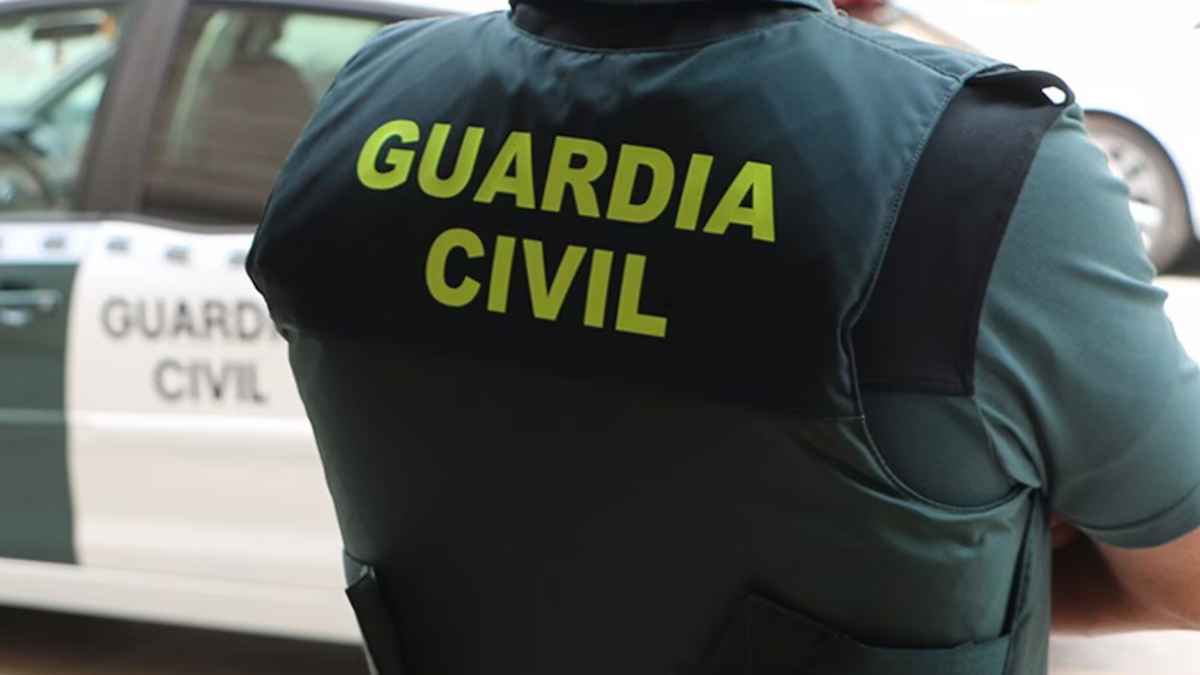 Agente de la Guardia Civil con chaleco oficial frente a vehículo patrulla, refuerzo de seguridad en supermercados españoles