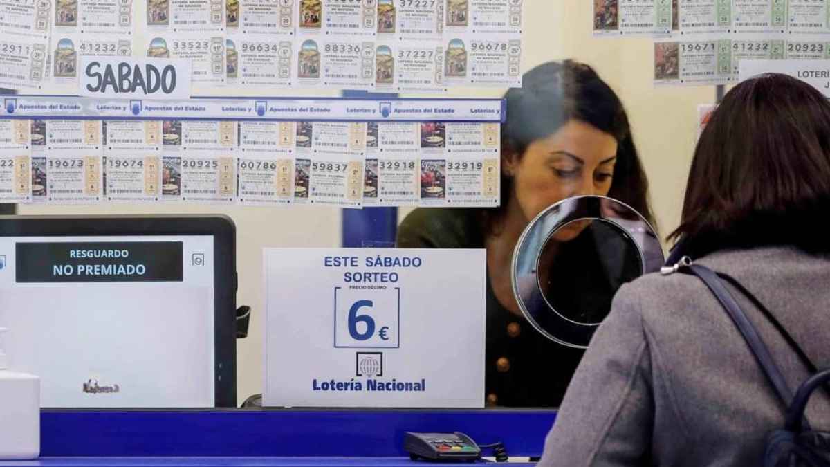 Mujer comprando décimo en administración de Lotería Nacional; cartel “resguardo no premiado” advierte riesgo de perder 73 millones