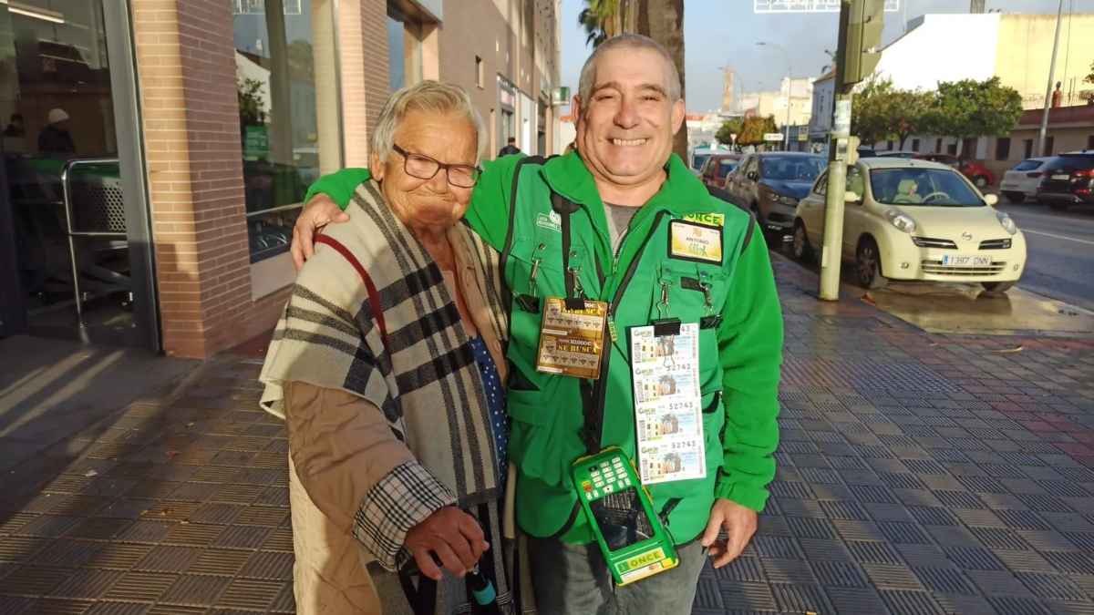 Jubilada junto al vendedor de lotería tras ganar premio millonario.