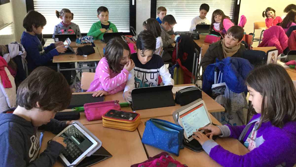 Niños en clase usando tablets y móviles, antes de la nueva medida de la Comunidad de Madrid sobre el uso de pantallas en Infantil y Primaria.