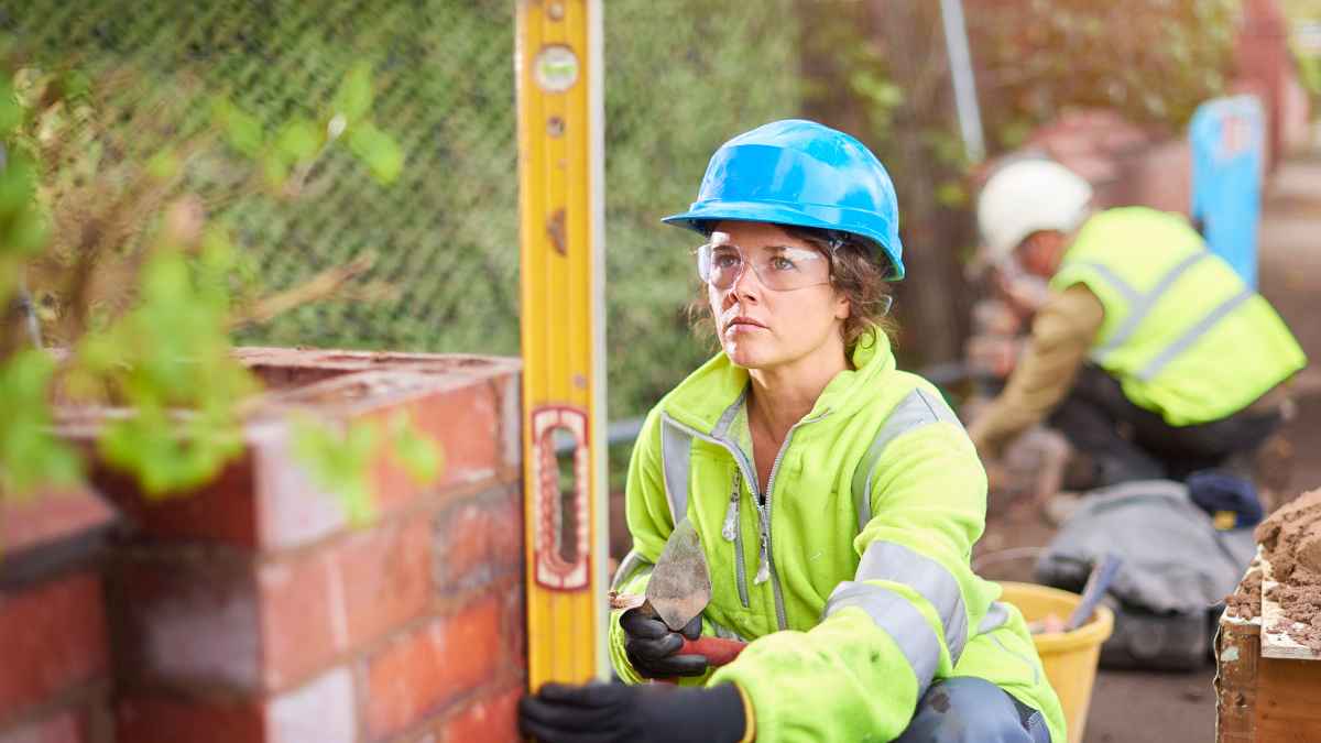 Mujer trabajando en la construcción alicatando y ganando 100 euros diarios
