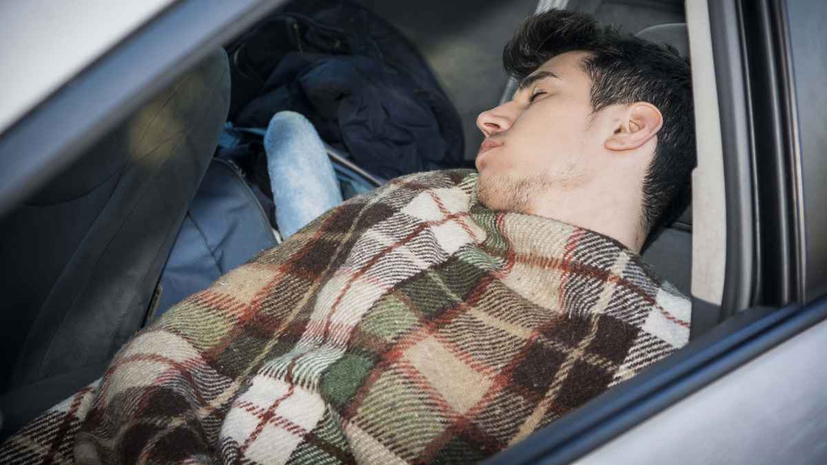 Hombre durmiendo dentro de su coche evitando multas de la DGT