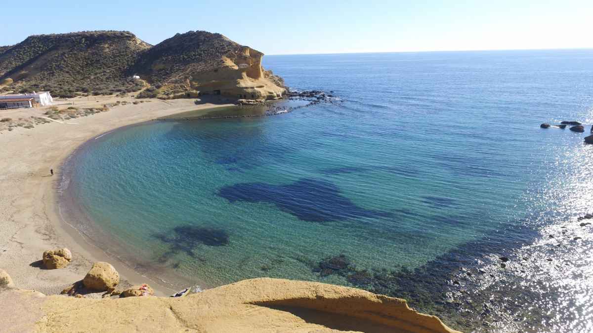 «Vista aérea de la playa de Cocedores, famosa por sus aguas cristalinas y acantilados, entre Murcia y Almería