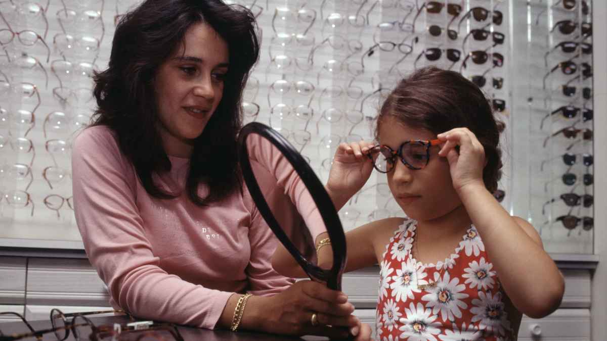 Niña probándose gafas graduadas gratuitas proporcionadas por la Seguridad Social
