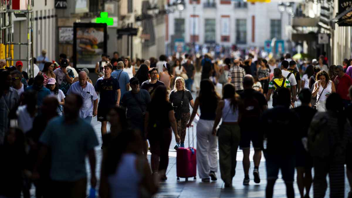 Personas caminando por una calle concurrida del centro de Madrid representando la clase media madrileña