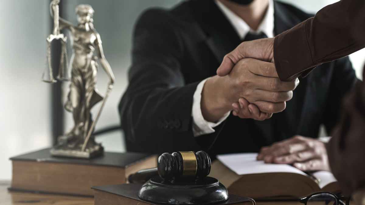 Notario en España estrechando la mano de un cliente junto a figura de justicia y mazo judicial