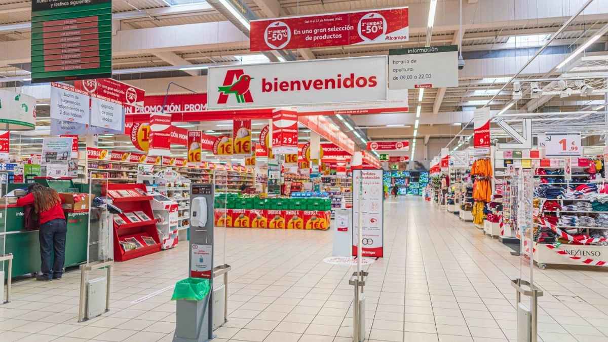 Entrada de supermercado Alcampo con carteles de bienvenida y ofertas en productos