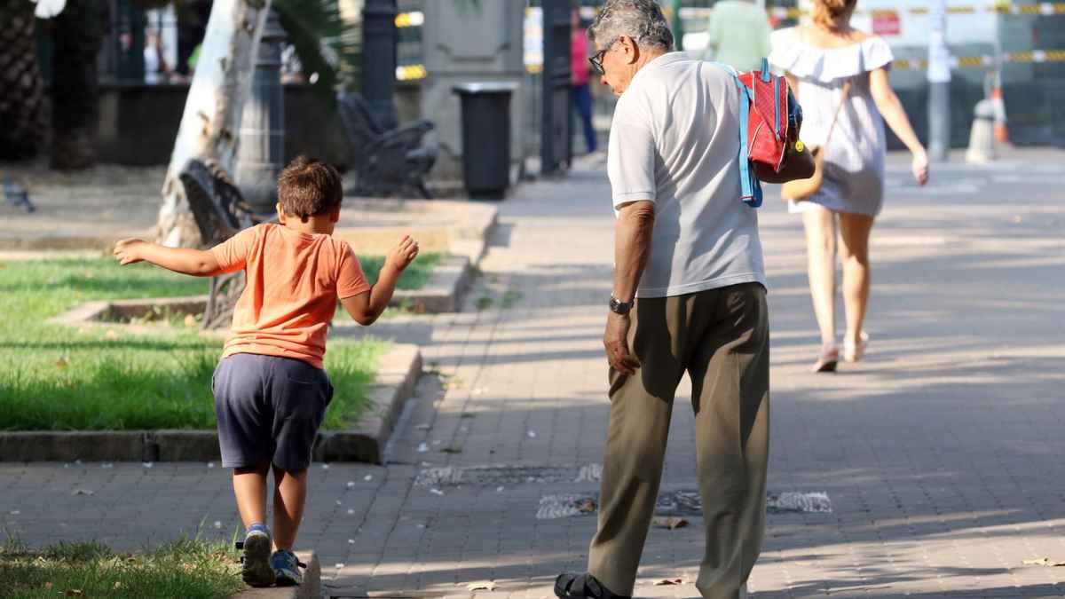 Hombre mayor paseando con niño, ejemplo de cuidado familiar que suma años de cotización para la jubilación.