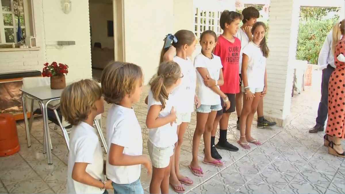 Siete de los 13 hijos de Elena Del Cerro alineados en el patio familiar durante la entrevista sobre su día a día.