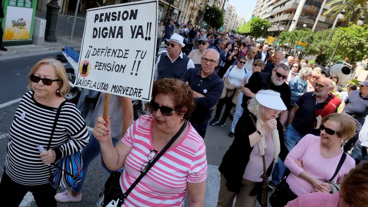 Manifestación de pensionistas reclamando una pensión digna y explicando los requisitos para solicitar pensiones no contributivas en España.