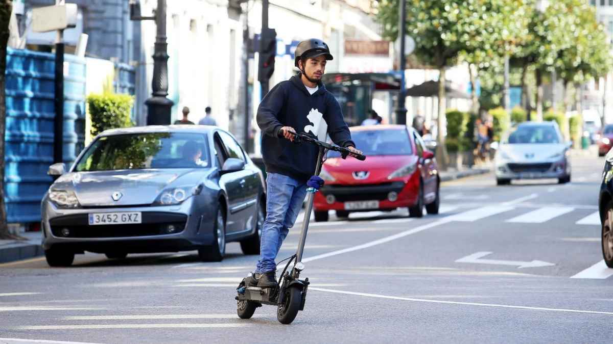 Conductor en patinete eléctrico por ciudad; ITV obligatoria para renovar el seguro de patinetes y bicis eléctricas.