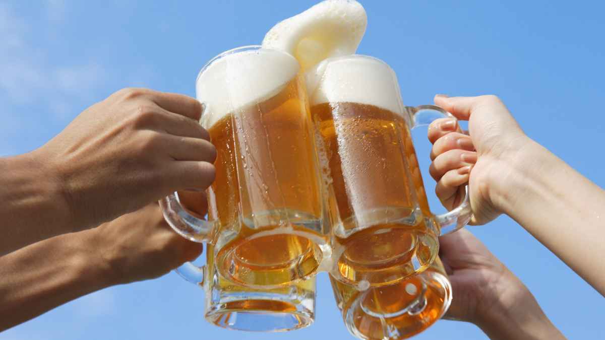 Manos brindando con jarras de cerveza en un evento festivo