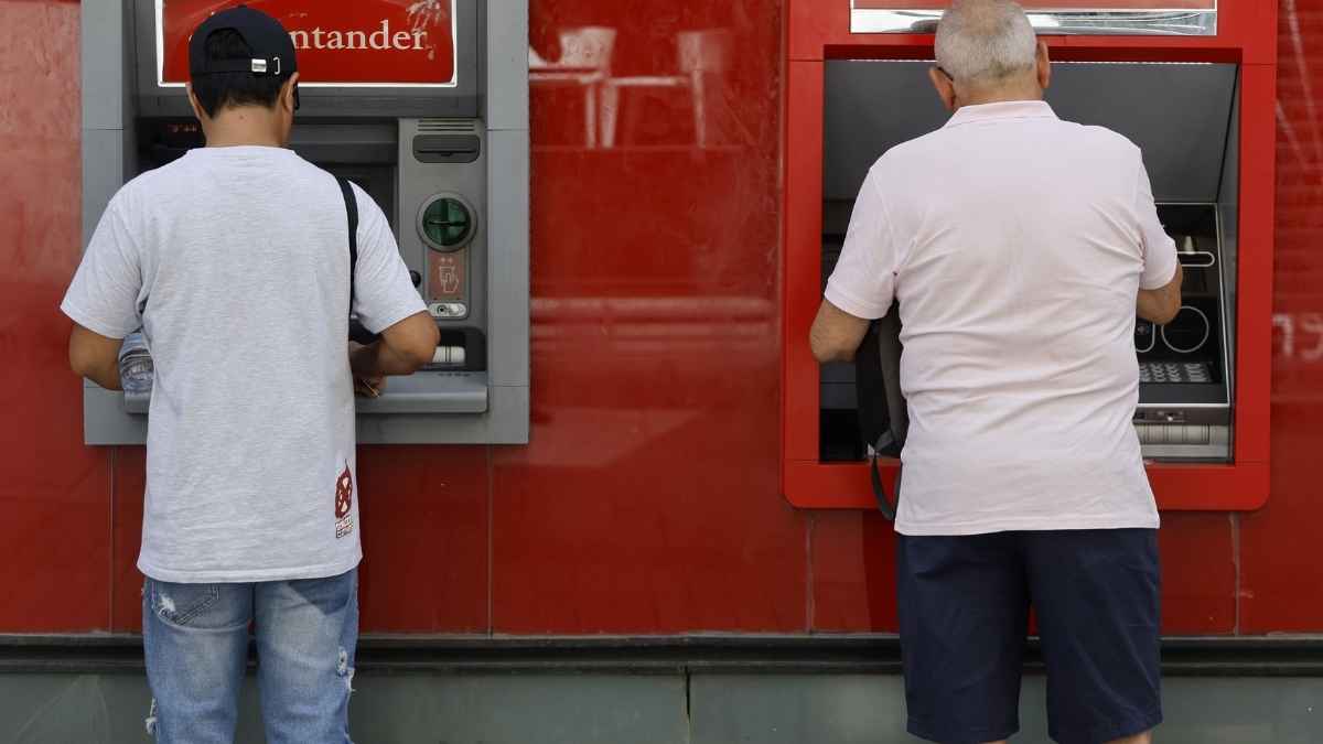 Dos hombres sacando dinero en cajeros automáticos uno de ellos jubilado relacionado con pensión de jubilación e incapacidad