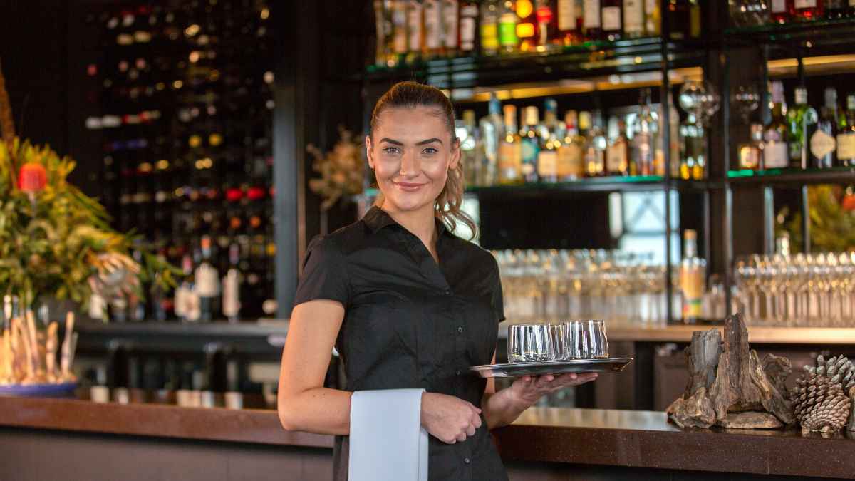 Camarera en un bar durante su jornada laboral antes de ser despedida estando de baja médica