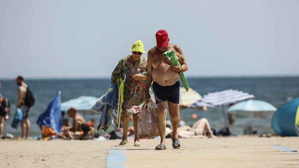 Pareja de jubilados caminando en la playa de Valencia, elegida mejor ciudad para jubilarse según estudio norteamericano