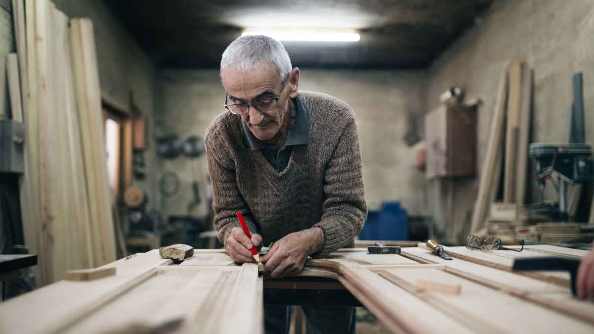 Trabajador senior retrasando su jubilación en un taller de carpintería para acceder a incentivos de la Seguridad Social de hasta 13.500 €.