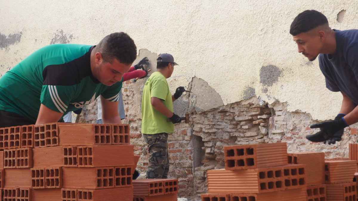 Peones de albañil apilando ladrillos en una obra en España, reflejo de la necesidad de vivienda y del sueldo mínimo legal 2025.