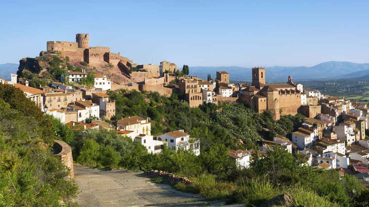 Vista panorámica de pueblo valenciano cerca de la playa con castillo y casas desde 30.000 euros