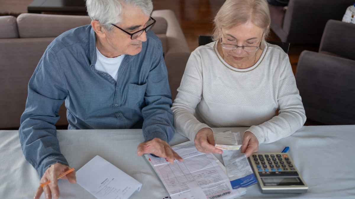 Pareja de jubilados calculando la reducción de su pensión por adelantar la jubilación