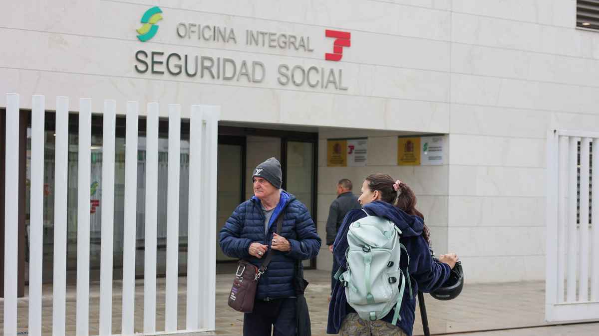 Personas frente a oficina de la Seguridad Social en España para trámites de jubilación y cotizaciones.