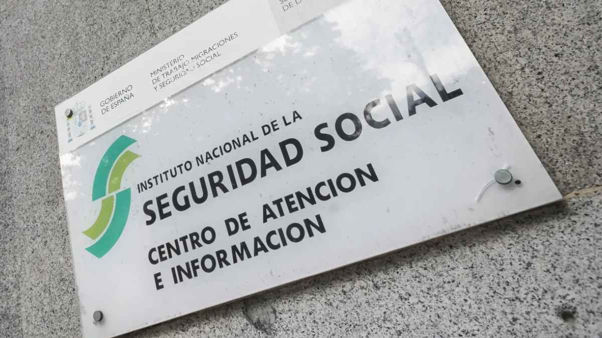 Fachada de oficina de la Seguridad Social en España con cartel informativo en la entrada principal
