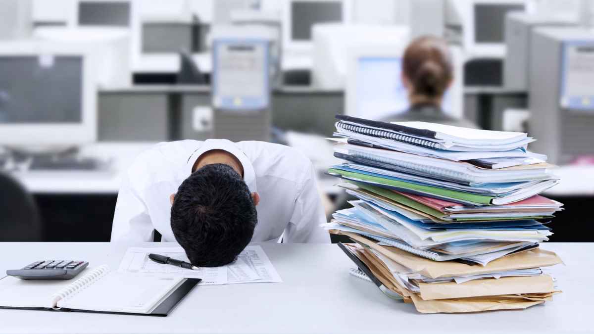 Trabajador con exceso de trabajo y estrés laboral en oficina en España 2025