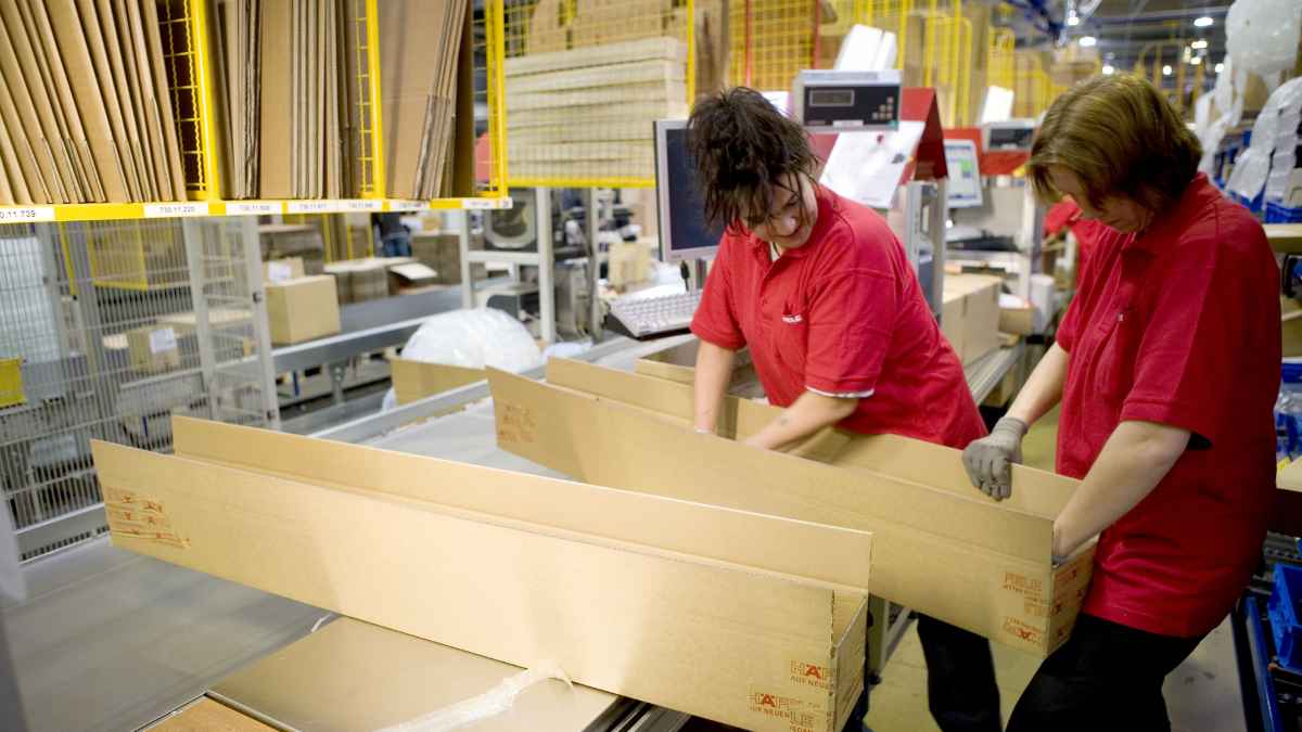 Trabajadores en almacén logístico en Alemania para ofertas de empleo con transporte y alojamiento organizado