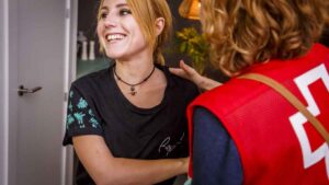 Voluntaria de Cruz Roja atendiendo a una persona en programas de empleo social en España