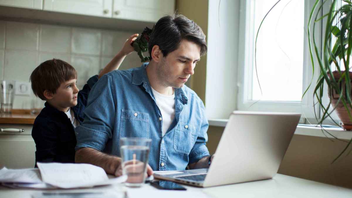 Padre teletrabajando con adaptación de jornada para cuidar a su hijo