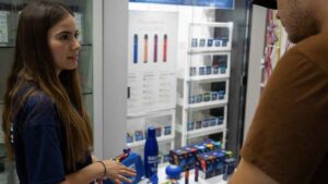 Azafata comercial en estanco de Madrid atendiendo a cliente con contrato fijo