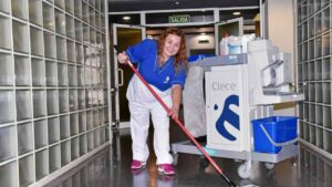 Trabajadora de limpieza de Clece con carrito de limpieza en oficina