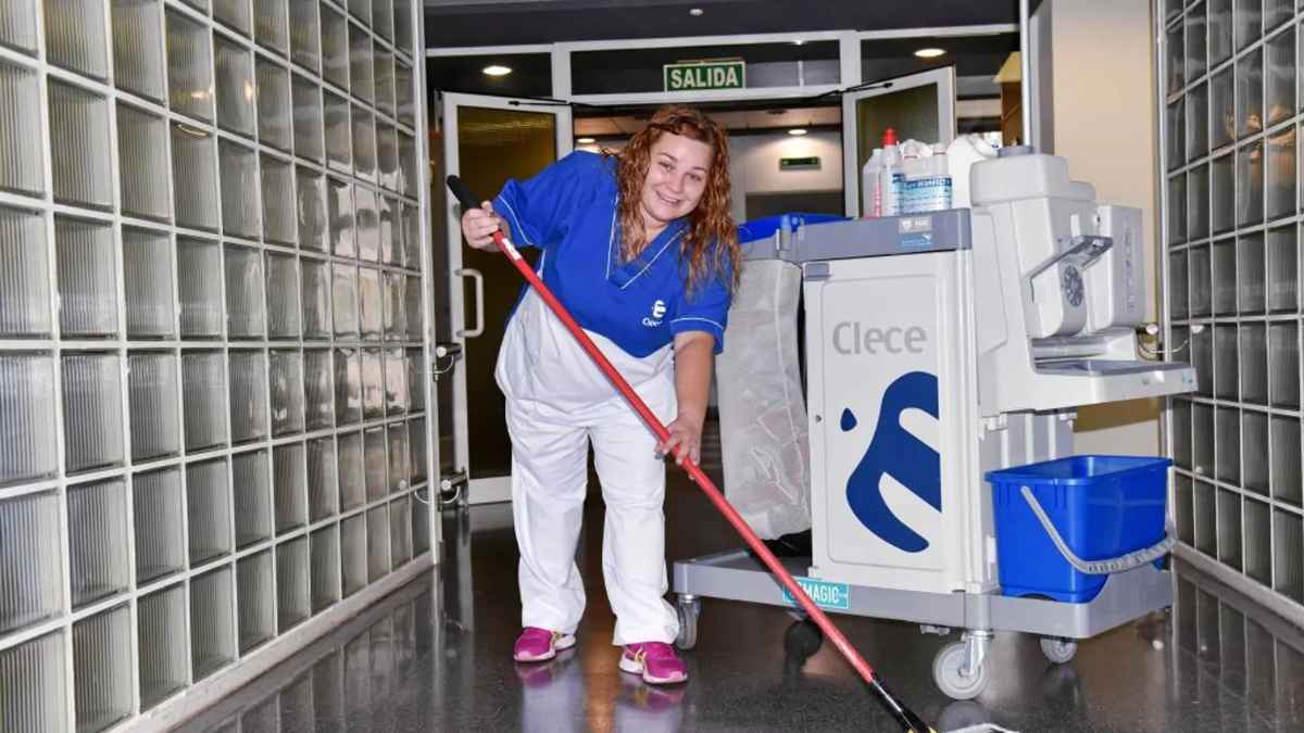 Trabajadora de limpieza de Clece con carrito de limpieza en oficina