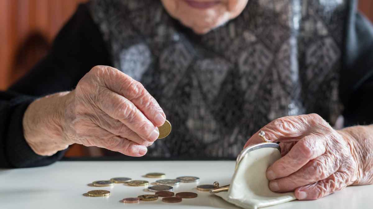 Persona mayor contando monedas, hucha de las pensiones en riesgo en la Seguridad Social