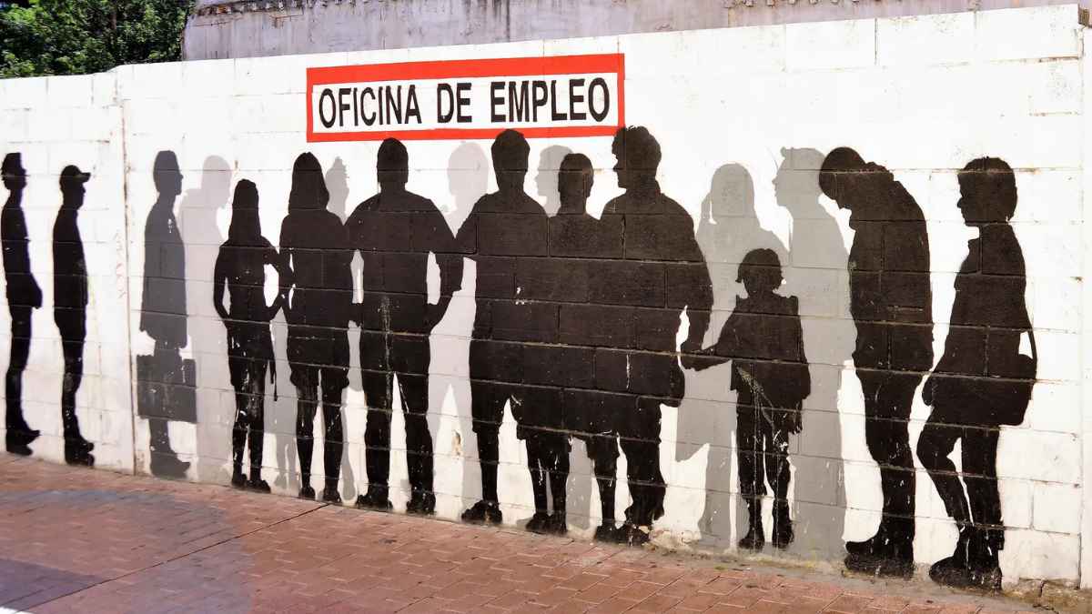 Personas en fila frente a oficina de empleo en España