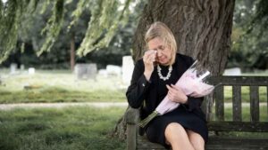 Mujer en cementerio tras negársele pensión de viudedad por no inscribirse como pareja de hecho