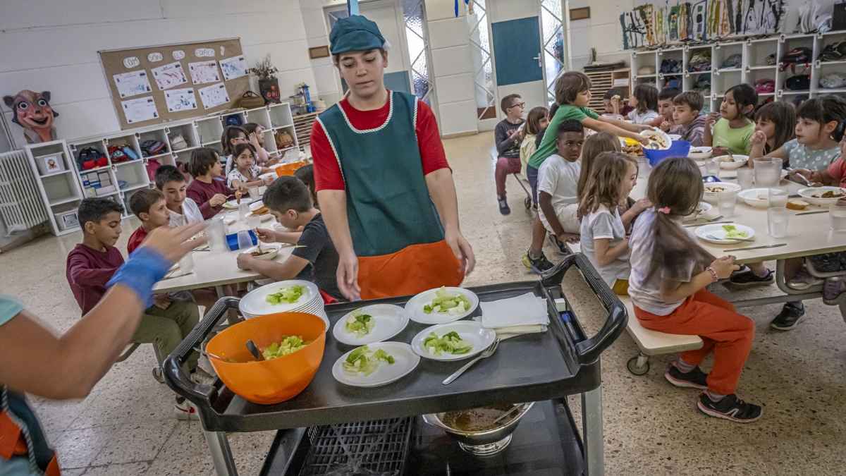 Auxiliar de limpieza en comedor escolar de Alcorcón sirviendo comida a niños