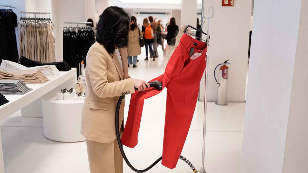 Empleada de tienda preparando prendas en una tienda de Inditex, relacionada con las ofertas de empleo en Zara y Bershka.