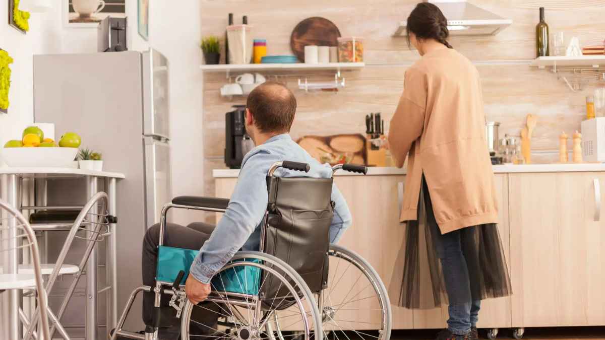 Persona en silla de ruedas recibiendo apoyo en casa, ejemplo de beneficiario de la Ley de Dependencia.