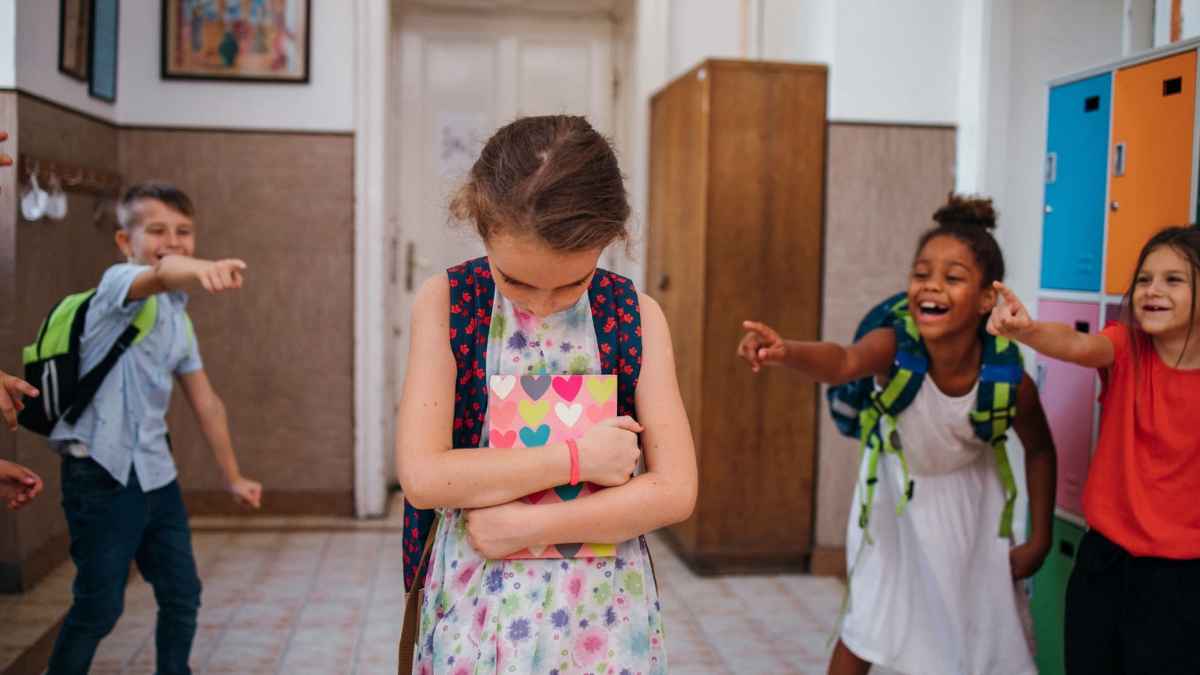 Niña acosada en el colegio mientras varios compañeros se burlan de ella en clase