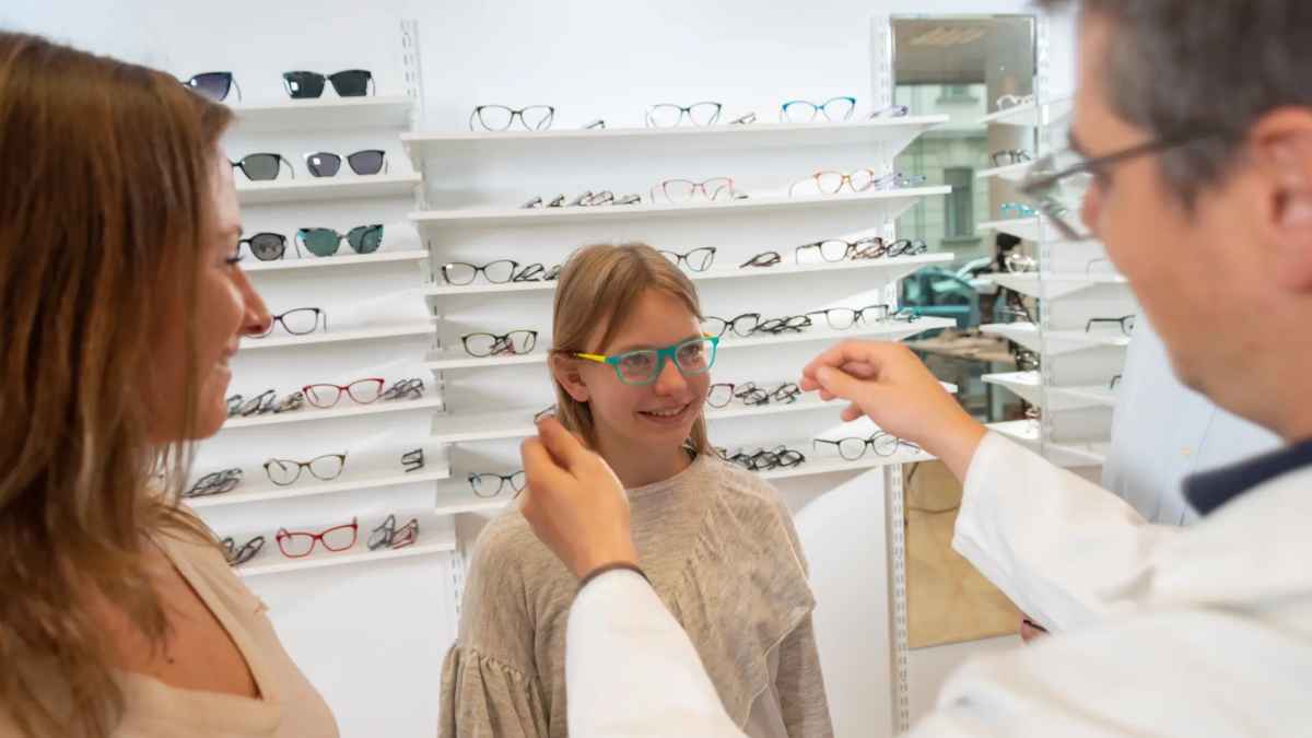Niña probándose gafas en óptica dentro del Plan Veo de ayuda de 100 euros