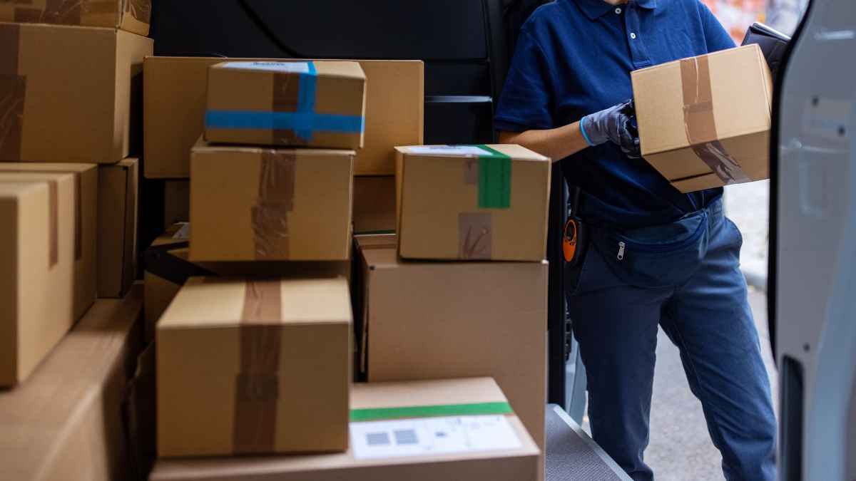 Repartidor de paquetería cargando cajas en furgoneta en Corvera Murcia