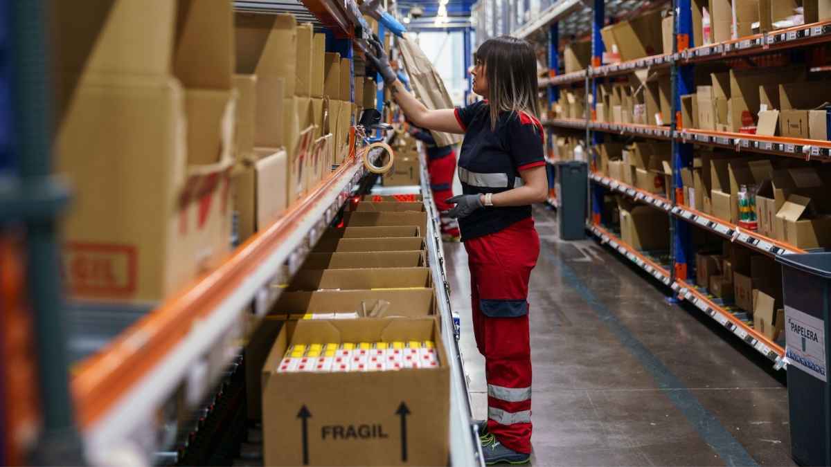 Mozo de almacén trabajando entre estanterías en centro logístico del SEPE