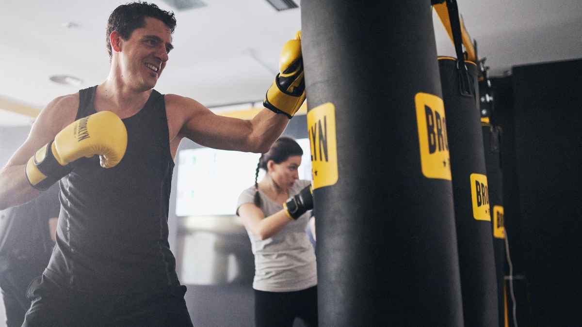 Trabajador en baja médica golpeando un saco de boxeo en un gimnasio