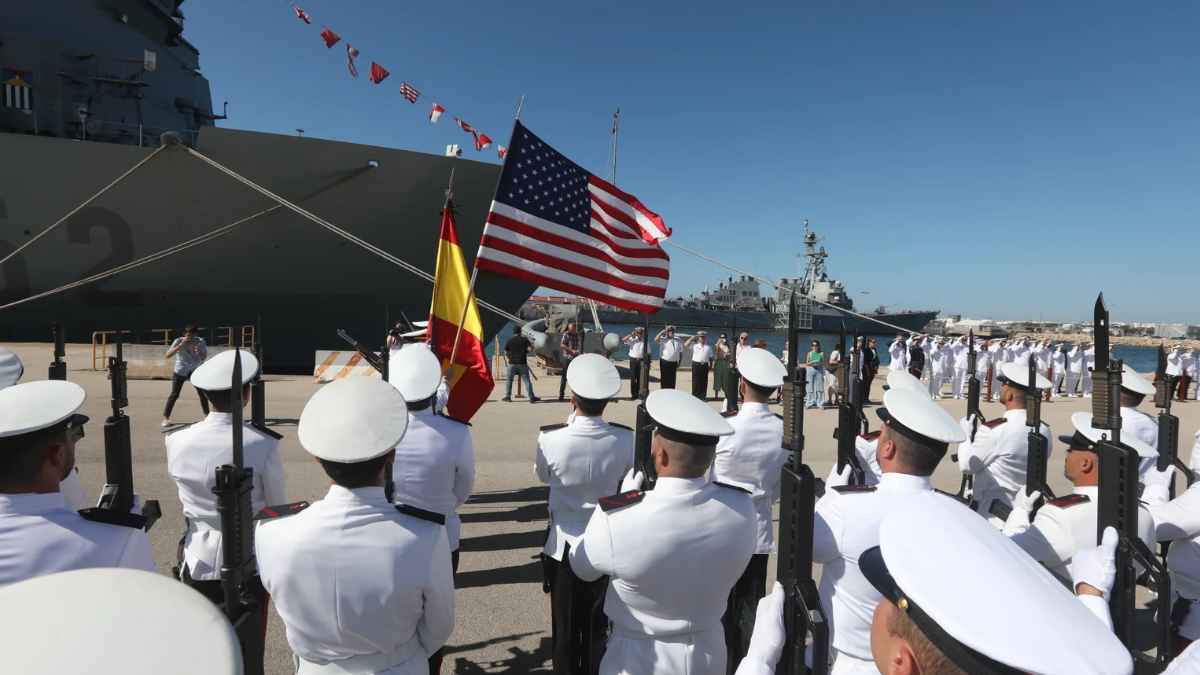 Ceremonia militar en la Base de Rota con marinos de España y Estados Unidos frente a buques de guerra.