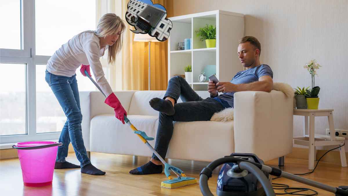 Mujer realizando tareas del hogar mientras un hombre descansa en el sofá, imagen relacionada con indemnización por trabajo doméstico.