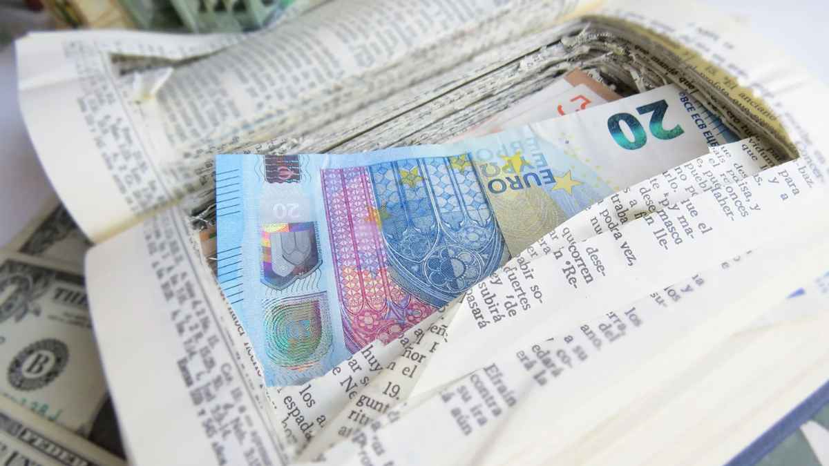 Billetes de euro escondidos en un libro como ejemplo de dinero en metálico guardado en casa