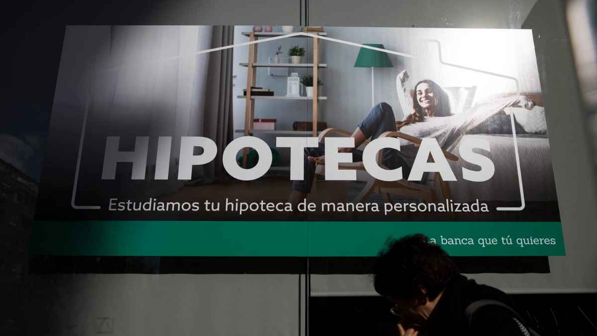 Cartel sobre hipotecas en una sucursal bancaria relacionado con la deducción por cancelación de préstamos según Hacienda.