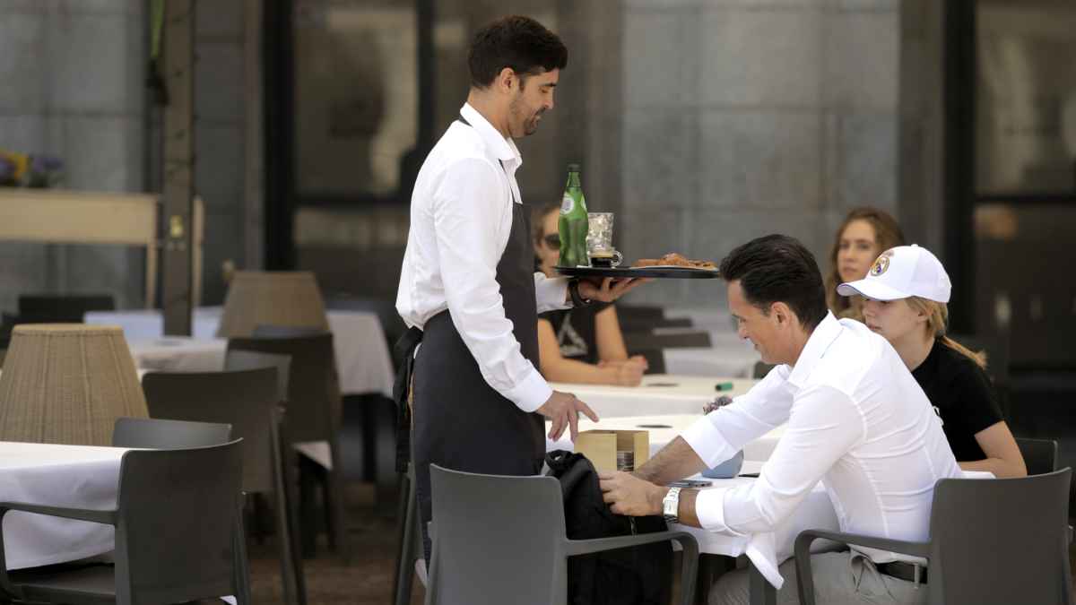Camarero trabajando en una terraza simboliza el récord de empleo y afiliación en España en octubre de 2025
