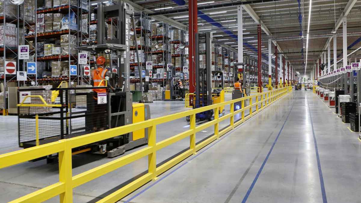 Trabajadores logísticos preparando pedidos con transpaleta eléctrica en empresa multinacional de Illescas Toledo