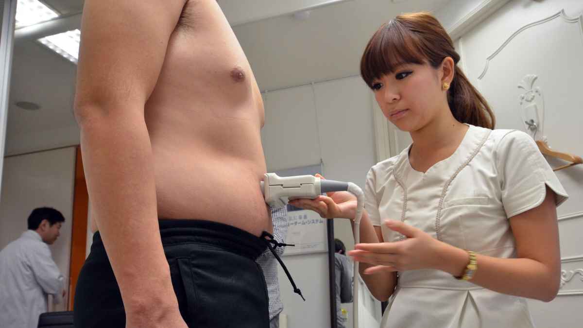 Trabajador japonés midiendo su cintura como parte de la Ley Metabo que controla la obesidad en Japón